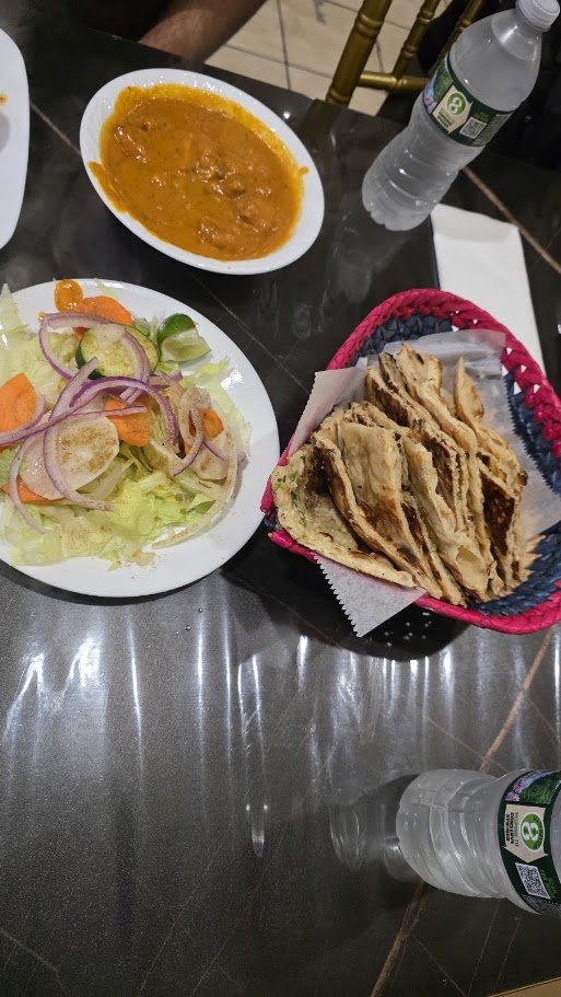 Indian dishes arranged on a casual restaurant table.