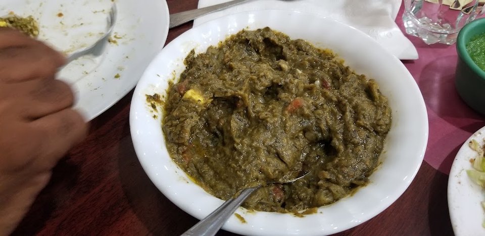Restaurant menu with vegetarian, fish, and goat options.